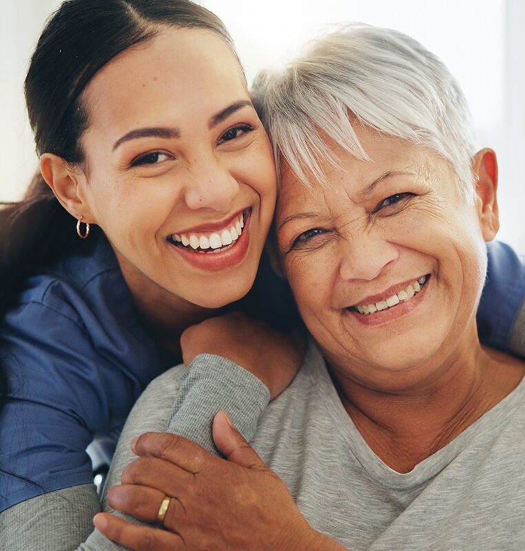 Happy woman, nurse and hug senior patient in elderly care, support or trust at old age home. Portrait of mature female person, doctor or medical caregiver hugging with smile for embrace at house